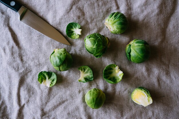 Photo high angle view of brussels sprouts with knife on fabric