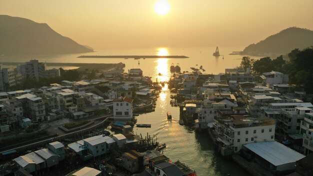 High angle view of buildings by sea against sky during sunset