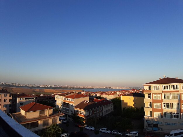 High angle view of buildings in city against blue sky