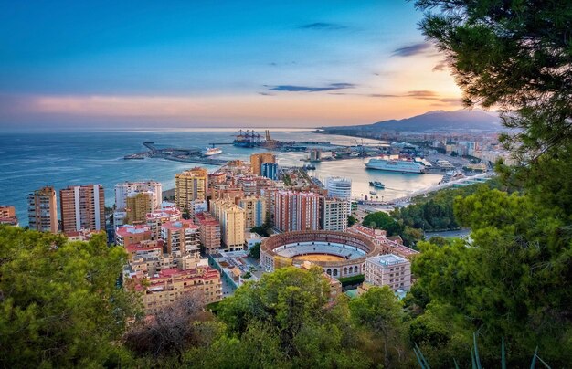 High angle view of buildings in town by sea against sky