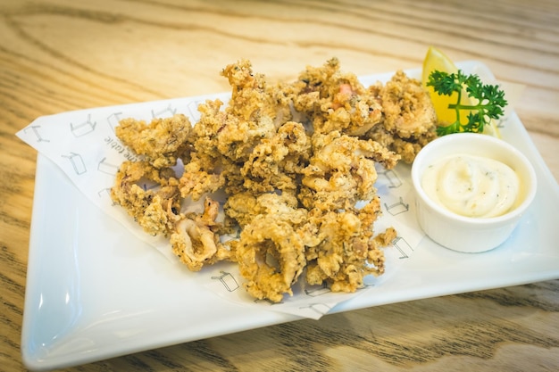 Photo high angle view of calamari with mayonnaise in plate on table