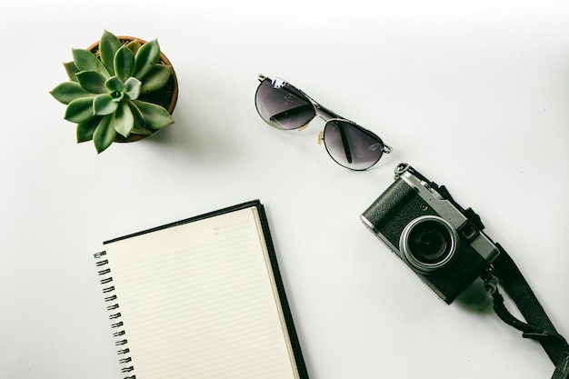 Photo high angle view of camera and potted plant with sunglass on white background