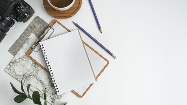 High angle view of camera with office supplies and coffee on white background