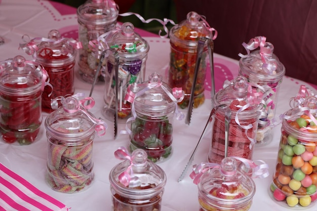 Photo high angle view of candies in glass jars on table