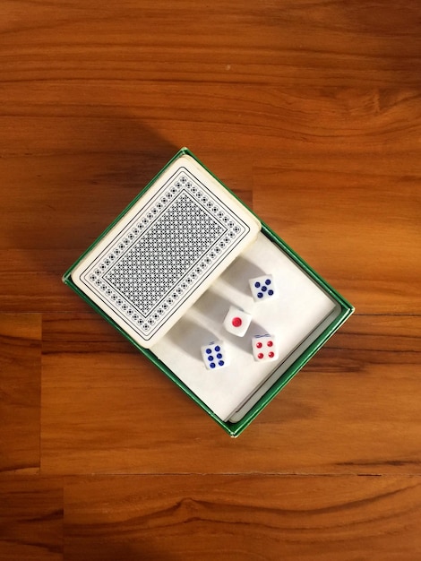 High angle view of cards with dices on wooden table