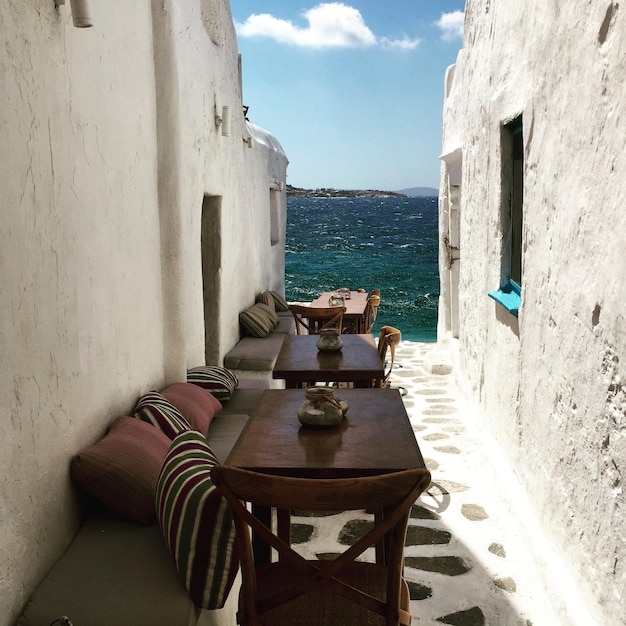 high angle view of chairs and tables arranged at alley against sea