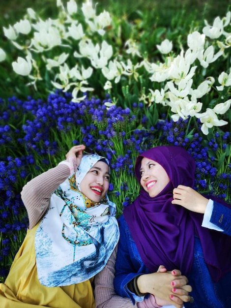 Photo high angle view of cheerful female friends lying on flowers