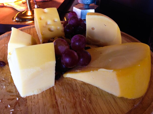High angle view of cheese slices and grapes on table