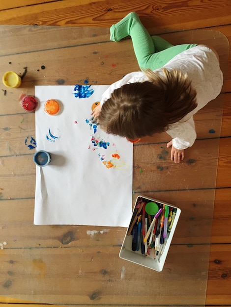 High angle view of child on hardwood floor