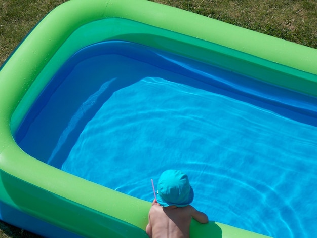 high angle view of child leaning on inflatable pool
