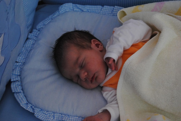 High angle view of child lying in crib