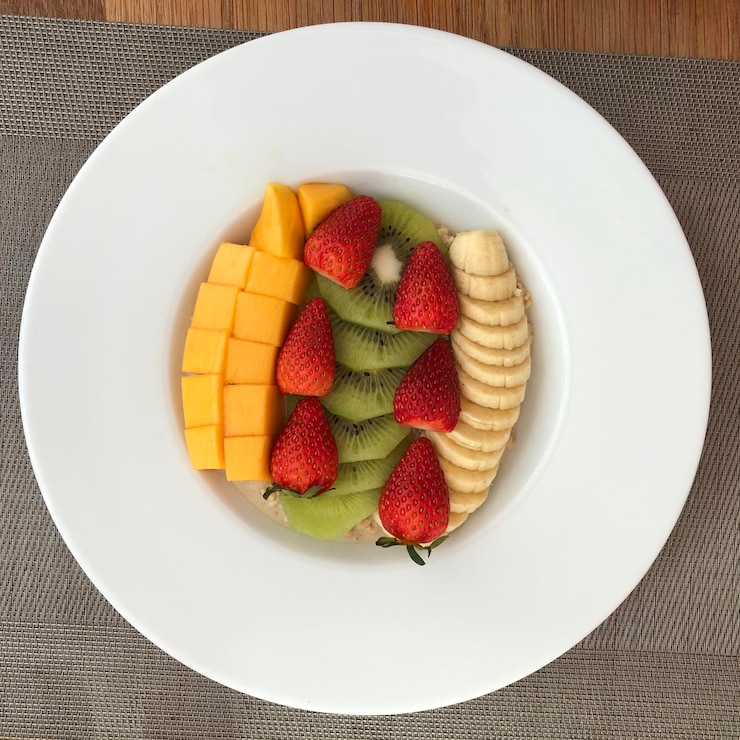 Photo high angle view of chopped fruits in plate on table