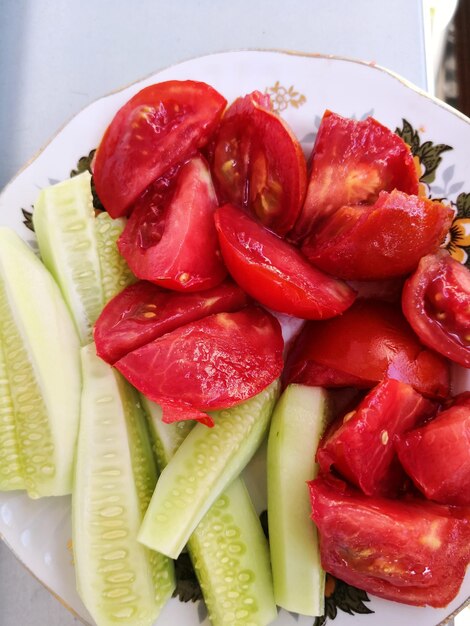 High angle view of chopped tomatoes and cucumbers in plate