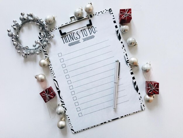 Photo high angle view of christmas decoration and clipboard against white background