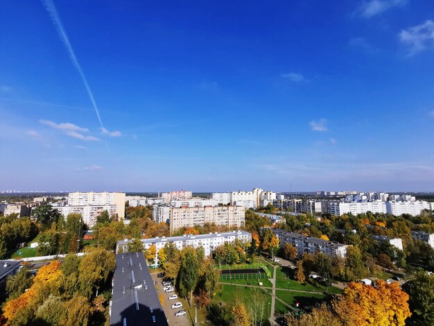 High angle view of city buildings against blue sky