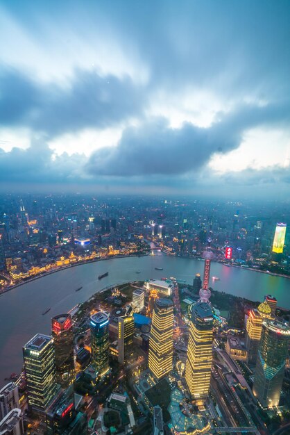 High angle view of city lit up against cloudy sky