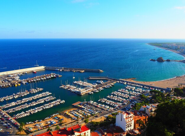 High angle view of cityscape by sea against clear sky