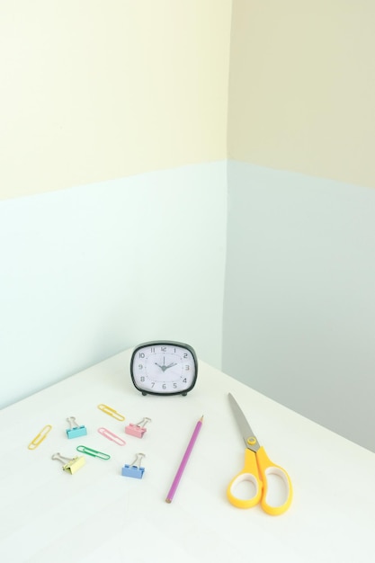 High angle view of clock and office supplies on table