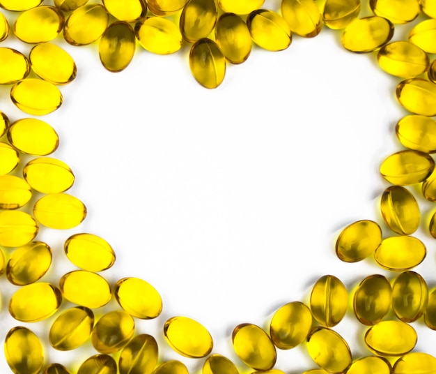 High angle view of cod liver oil capsules making heart shape over white background