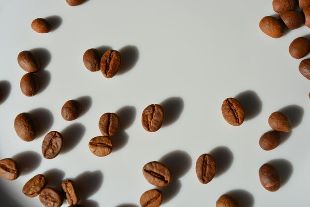 High angle view of coffee beans over white background