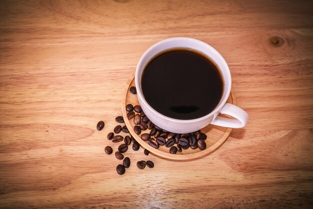 High angle view of coffee cup and beans on table