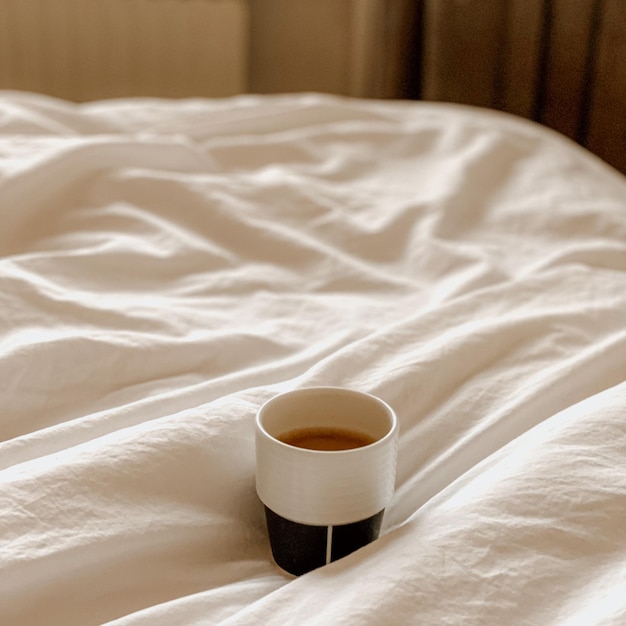 High angle view of coffee cup on bed