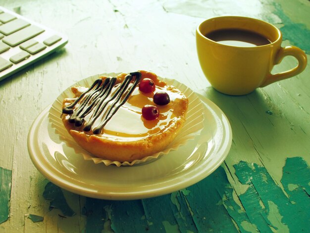 https://img.freepik.com/premium-photo/high-angle-view-coffee-cup-tart-with-computer-keyboard-wooden-table_1048944-11007183.jpg