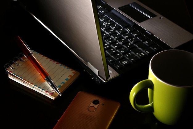 High angle view of coffee cup with laptop on table