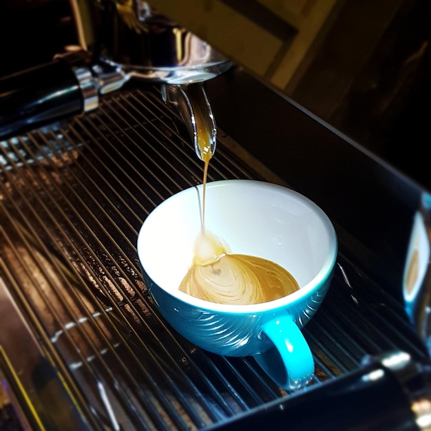 High angle view of coffee pouring in cup