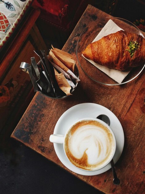 Foto vista ad alta angolazione del caffè con croissant sul tavolo