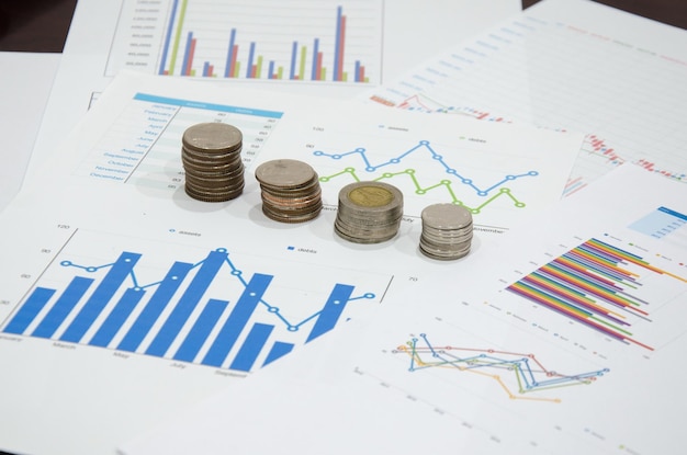 High angle view of coins on chart paper