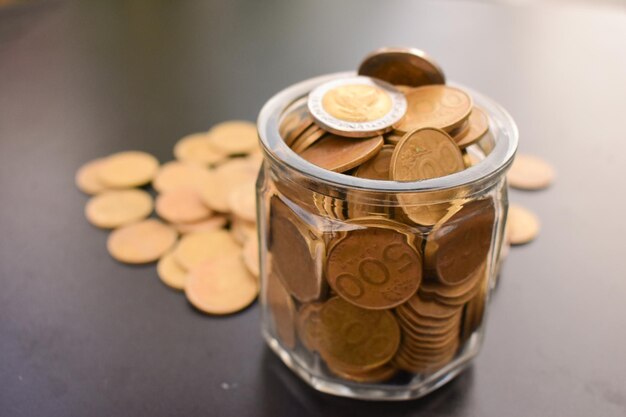 High angle view of coins in jar on table