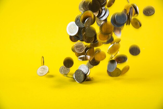 High angle view of coins on yellow background