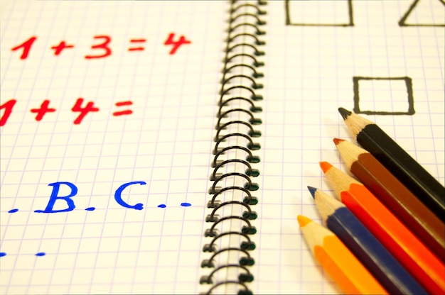 high angle view of colored pencils on spiral notebook