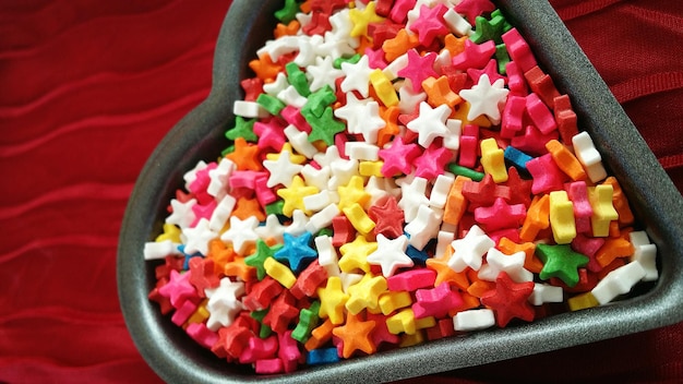 High angle view of colorful candies in heart shape container