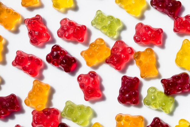 High angle view of colorful gummi bears on white background