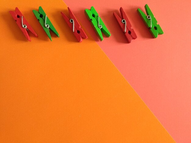 High angle view of colorful wooden clothespins on colored background