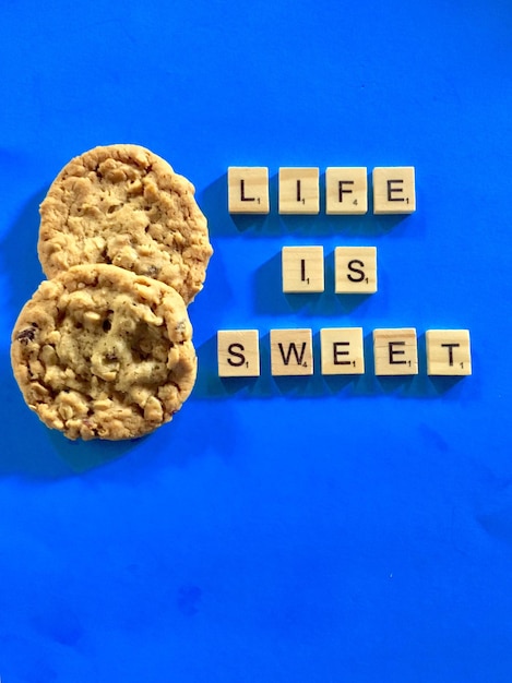 Photo high angle view of cookies against blue background life is sweet