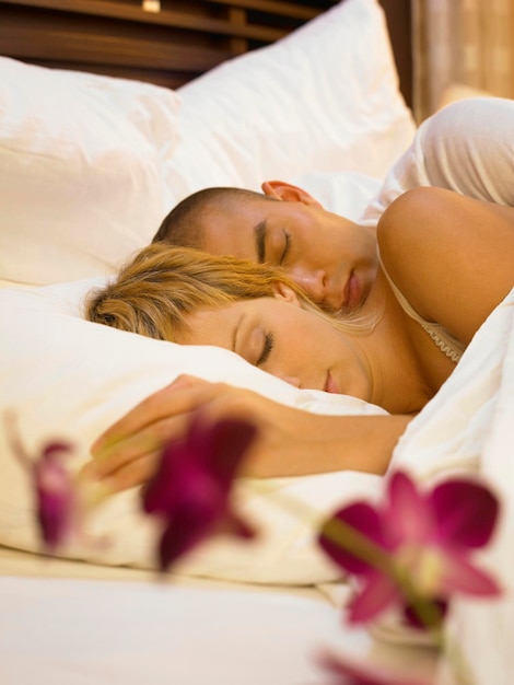 High angle view of couple sleeping on bed at home