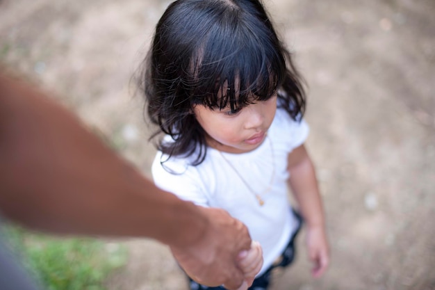 high angle view of cropped hand holding girl