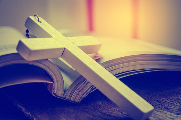 High angle view of cross with bible on table