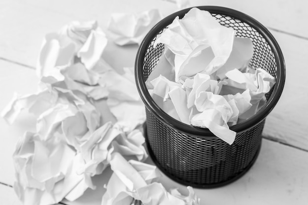 Photo high angle view of crumpled papers by garbage can on floor