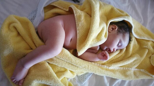 Photo high angle view of cute baby boy sleeping on bed