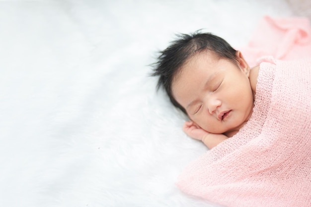家でベッドで寝ている可愛い赤ちゃんの高角度ビュー