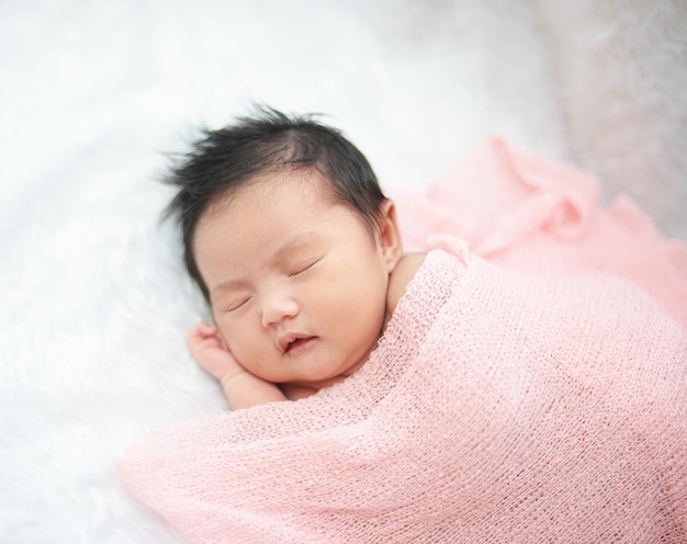 家のベッドで寝ている可愛い赤ちゃんの高角度の視点
