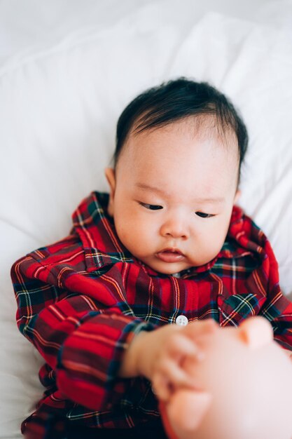 High angle view of cute baby lying on bed