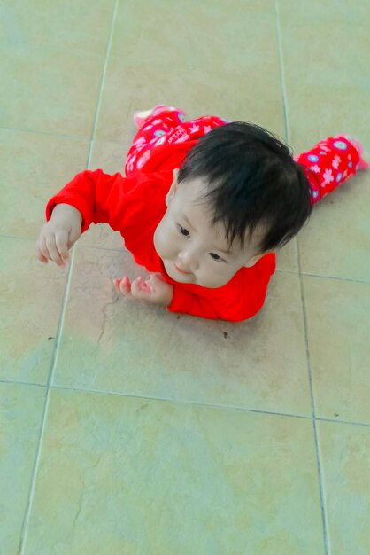 Photo high angle view of cute baby lying on floor at home