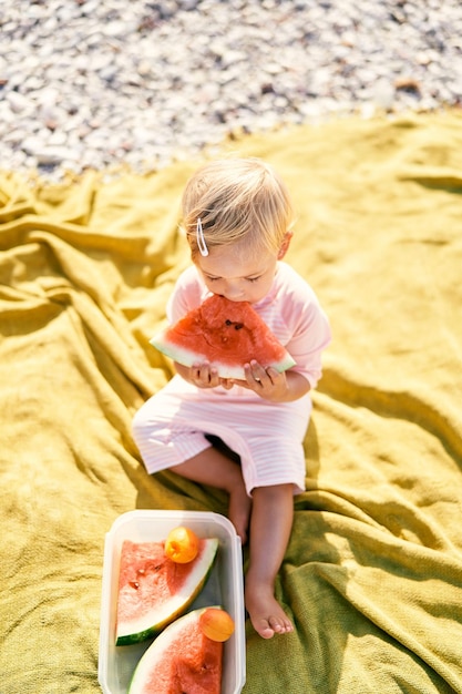 High angle view of cute girl sitting on sand at beach