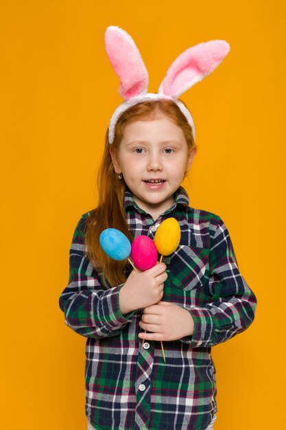 High angle view of cute girl with balloons against yellow background