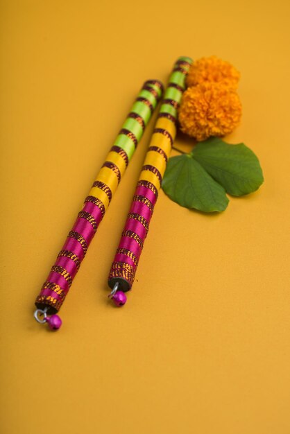 Foto vista ad alta angolazione di dandiya con marigold su sfondo giallo